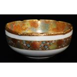 A Japanese Satsuma bowl, decorated with a dense mass of gilt and coloured flower heads to the