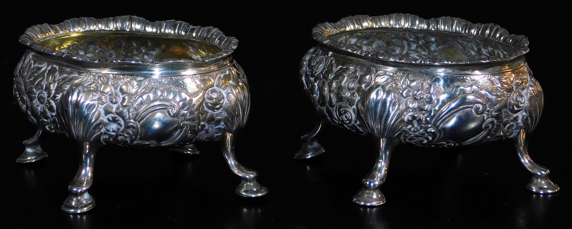 A pair of late 18thC silver salts, of oval form, heavily repousse decorated with a repeat floral