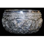 An early 20thC Indian ceremonial bowl, heavily repousse decorated with figures scrolls and