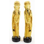A pair of faux ivory figures, formed as a lady and gentleman in flowing robes on fixed bases, 45cm