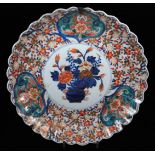 A Japanese Imari charger, of shaped floral form, centred with a vase of flowers, with an outer