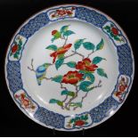 A 20thC Japanese dish, of shaped circular form decorated with flowering shrubs and bird with an