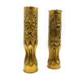 A pair of Greek WWI trench art brass shell cases, one embossed with crossed flags, a crown, flowers,