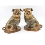 A pair of Scottish Bo'ness pottery pug dogs, c1900, modelled in seated pose with glass eyes, 31cm