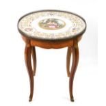A late 19thC French occasional table, with a circular porcelain top, with gilt and floral garland