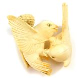 A Japanese ivory okimono, of a pair of sparrows squabbling over a head of millet, Meiji period, 11cm
