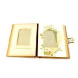 A Victorian cloth bound photograph album, embossed with flowers, with brass clasp, opening to reveal