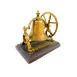 A brass bell form table bell, raised on a wooden base, 18cm wide, 12cm deep.