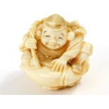 A Japanese ivory netsuke of Ebisu, seated on his giant carp, Meiji period, 6cm High.