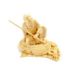 A Japanese ivory okimono figure of a seated fisherman, with bamboo rod, seated on his creel, crab