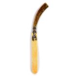 A Scottish late 19thC ivory paper knife, with a horn handle, and white metal mount, cast as the