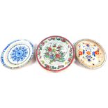 Three antique porcelain chargers, comprising a 19thC riveted Chinese famille rose example, 42cm