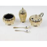 A silver three piece condiment set, of fluted gourd form, with blue glass liners, and spoons, Adie