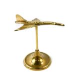 A brass desk stand modelled as Concorde, 16.5cm wide.