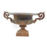 A 19thC cast iron urn, with leaf scroll handles, semi fluted raised on a square pedestal base,