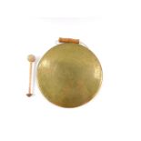 A Middle Eastern brass hand held dinner gong, with beater, 27cm diameter.