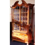 A Dutch 18thC style mahogany bombe display cabinet, the broken arch pediment over two glazed doors