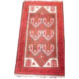 A Caucasian red ground prayer rug, decorated with six central geometric motifs and lanterns,