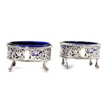 A pair of Victorian silver oval salts, with blue glass liners, pierced and engraved with birds and