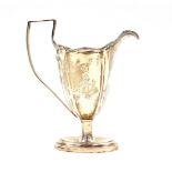 An Edward VII Adam style silver cream jug, of fluted and footed form, crest engraved, London 1904,
