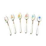 A set of six silver gilt and enamel coffee spoons, painted with flowers against a white guilloche