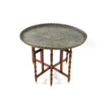 An Indian silvered metal tray top table, with turned folding base, 76cm diameter.