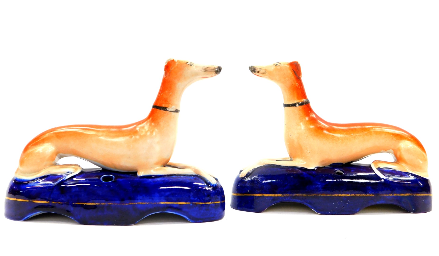 A pair of Staffordshire 19thC pottery greyhound ink wells, each modelled in recumbent pose on a blue