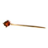 A Victorian topaz stick pin, intaglio carved with a classical goddess, set with four diamonds at