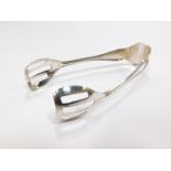 A pair of Continental cake serving tongs, white metal, with embossed shell and scroll moulding,