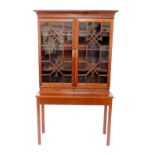 A Chippendale style mahogany bookcase on stand, the outswept pediment with dentil moulding and blind