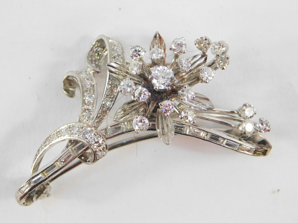 A diamond set floral spray brooch, baguette and brilliant cut diamonds, set in white metal,