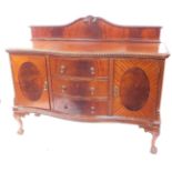An early 20thC mahogany serpentine sideboard, with shaped splash back, gadrooned top, three