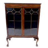 An early 20thC mahogany bow front display cabinet, with gadrooned top, astragal glazed doors,