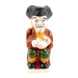 A Staffordshire mid 19thC grotesque Toby jug, modelled traditionally seated with a jug of frothing