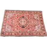 A Caucasian red ground rug, decorated with a central medallion, floral and foliate motifs, 159cm x