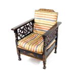 An early 20thC Japanned black lacquer and chinoiserie decorated reclining armchair, with fret work