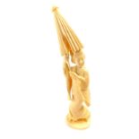 A Japanese ivory okimono figure of a geisha holding a parasol aloft, signed to base, 21cm high.