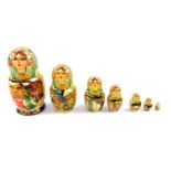 A Russian nest of seven Matryoshka or Babushka dolls, each ornately painted, with reserves of winter