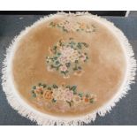 A Chinese circular wool rug, with beige ground and floral decoration, 142cm diameter.