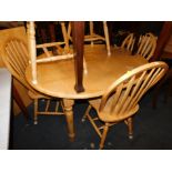 A beech extending kitchen table, together with six matching spindle back chairs. (7)