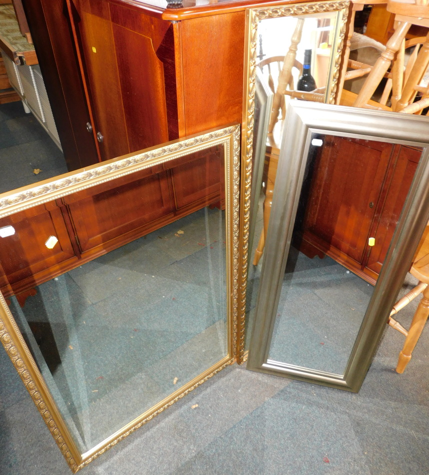 Three wall mirrors, comprising two gilt framed mirrors and a silver framed mirror, 123cm x 35cm,