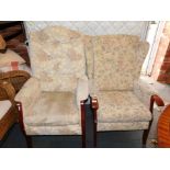 Two wooden framed easy chairs, upholstered in a floral chenille fabric.