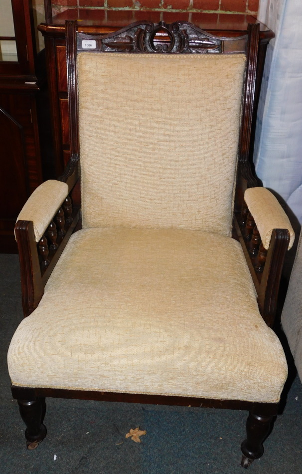A Victorian armchair, upholstered in a fawn coloured chenille.