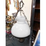 A cast iron ceiling light, of oil lamp form, with chimney and white glass shade, 45cm high, 31cm