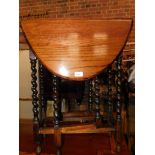 A stained oak drop leaf side table, with barley twist legs, 73cm high, 101cm wide, 58cm deep.