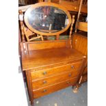 An oak early 20thC dressing chest, with oval swing mirror above three drawers, 146cm high, 91cm