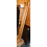 Three wooden curtain poles, with rings, together with a tall mirror. (4)