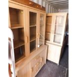 An oak effect glazed bookcase, raised on a sideboard base, together with another matching narrower