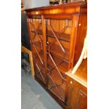 A reproduction mahogany glazed bookcase, with astral glazed doors raised on a plinth base, 153cm