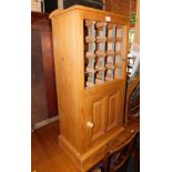 A waxed pine wine cabinet, above a single cupboard door, 106cm high, 50cm wide, 29cm deep.